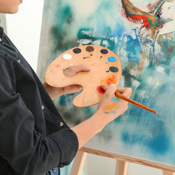 weibliche Künstlerin malt auf Leinwand