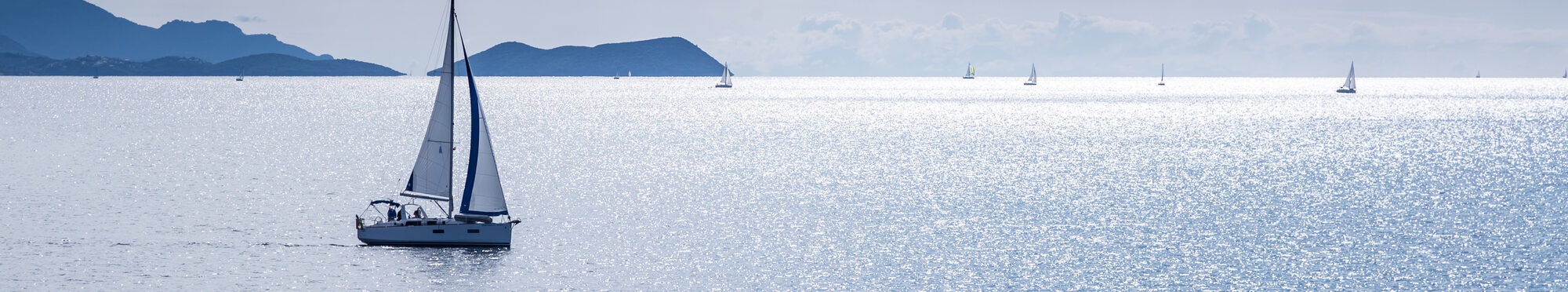 Sailing boat on blue sea waters with clear blue sky